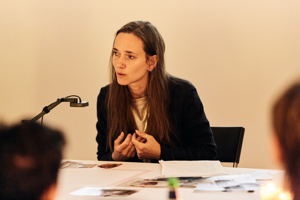 Woman sitting at a table in active discussion.